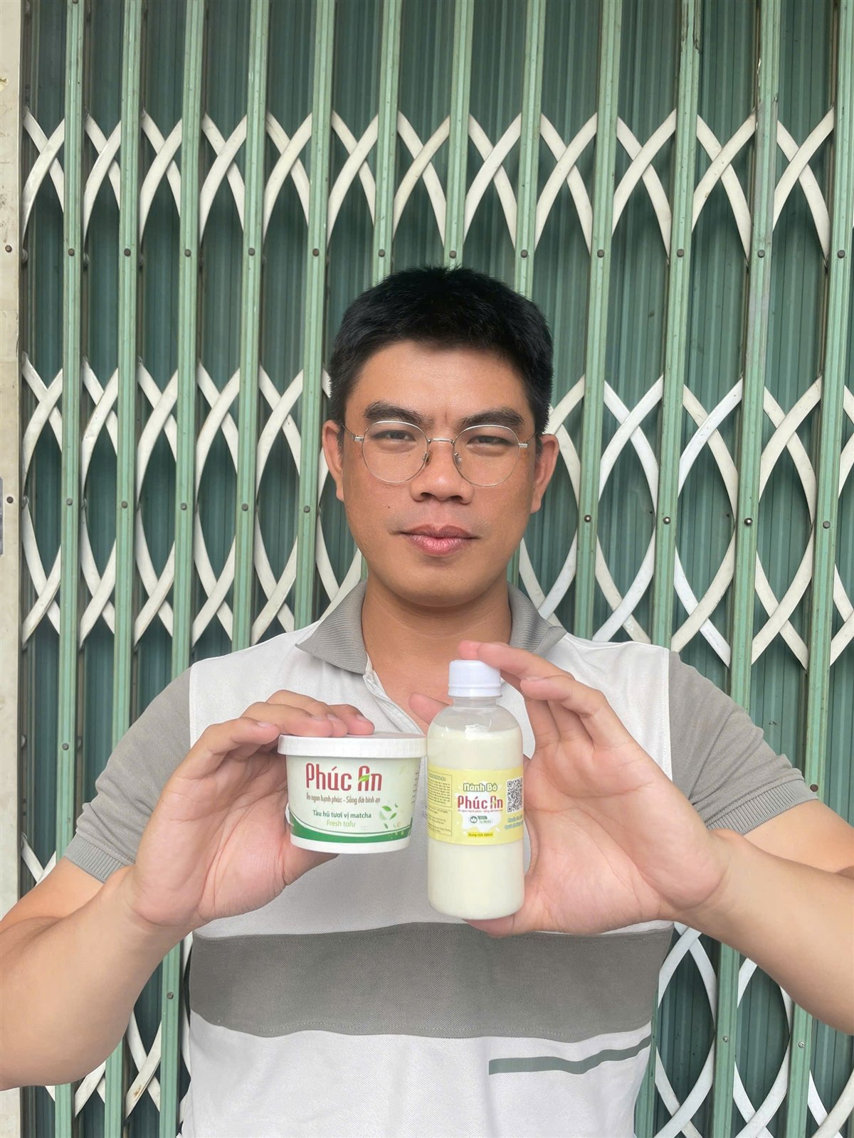 Đức - Founder Tàu Hũ Tươi Phúc An, cầm hũ tàu hũ tươi Matcha và chai Nành Bò Phúc An